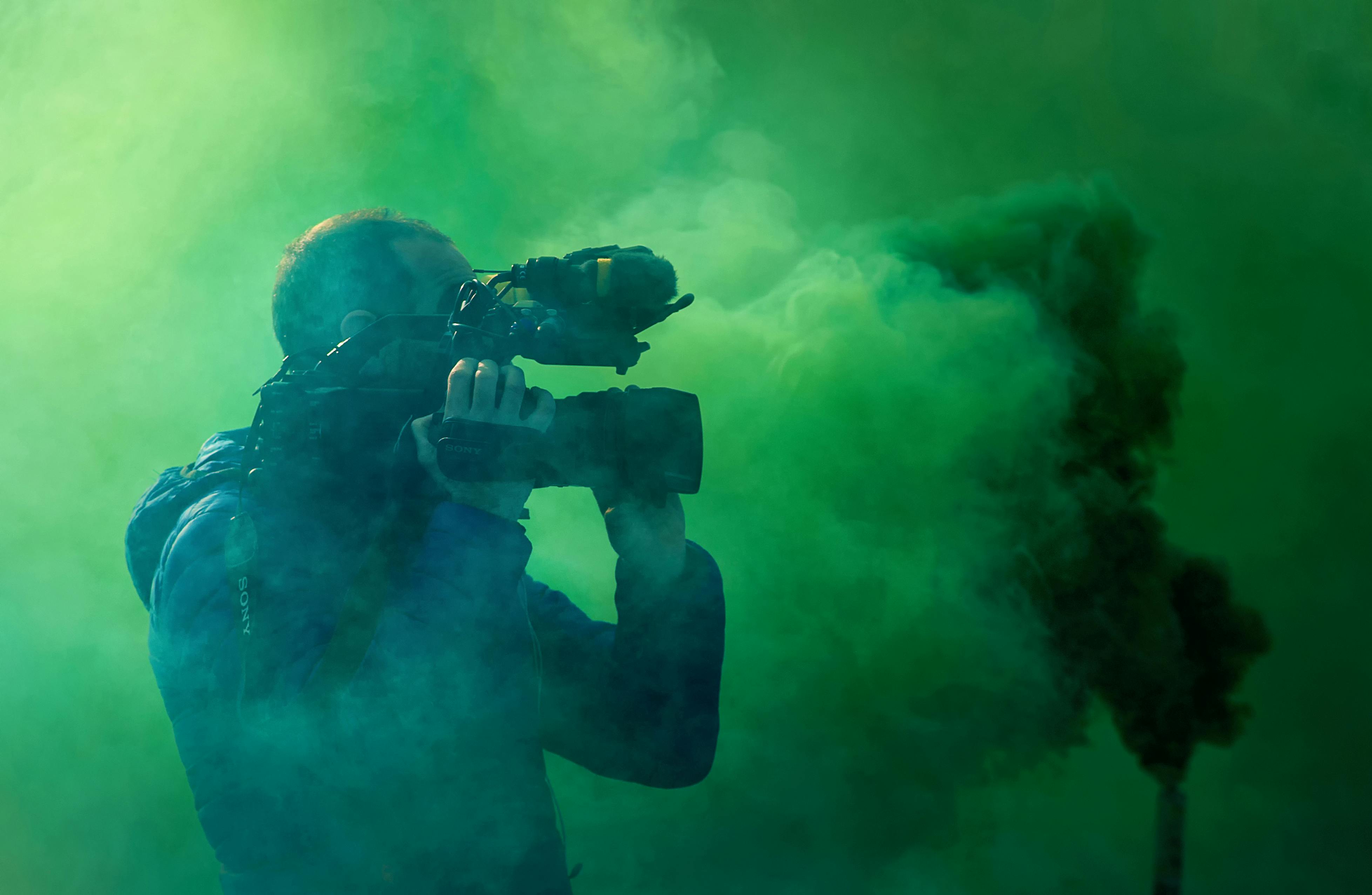 A filmmaker filming smoke on a greenscreen
