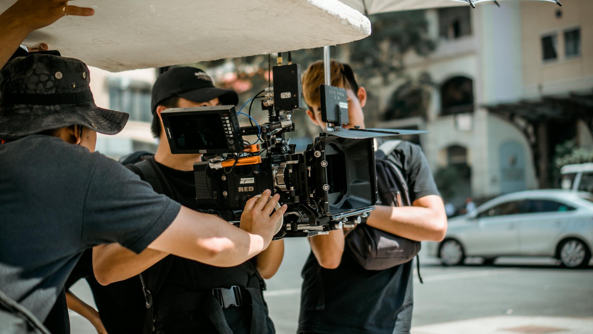 a film crew hold a camera